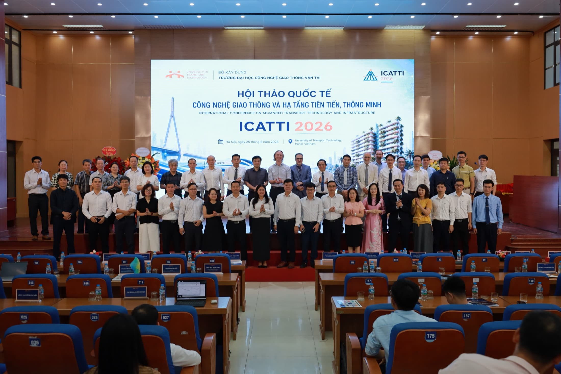 ICATTI 2026 delegates and speakers in a group photo on the main auditorium stage